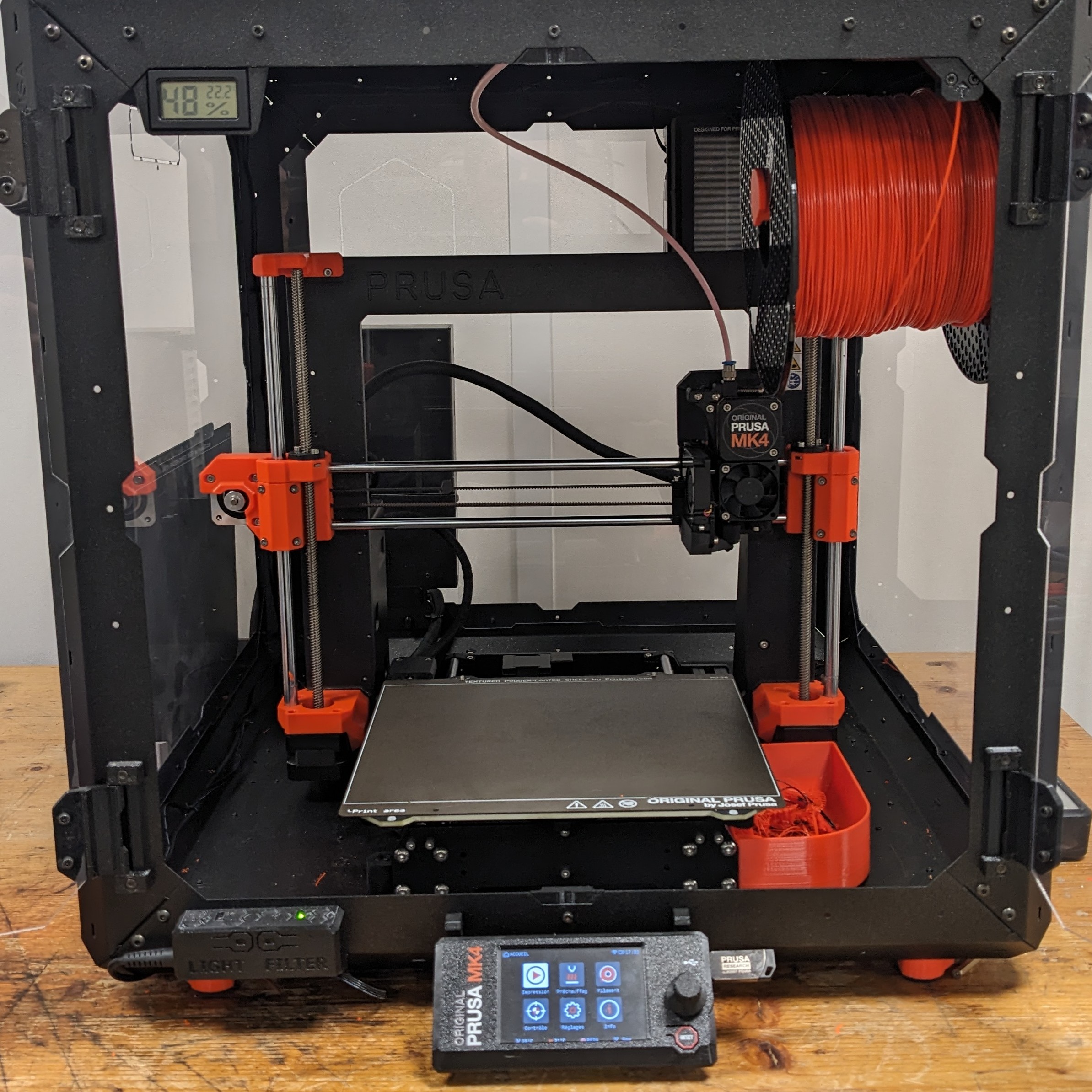 Imprimante 3D Prusa MK4 dans son boîtier, déployée dans un atelier
